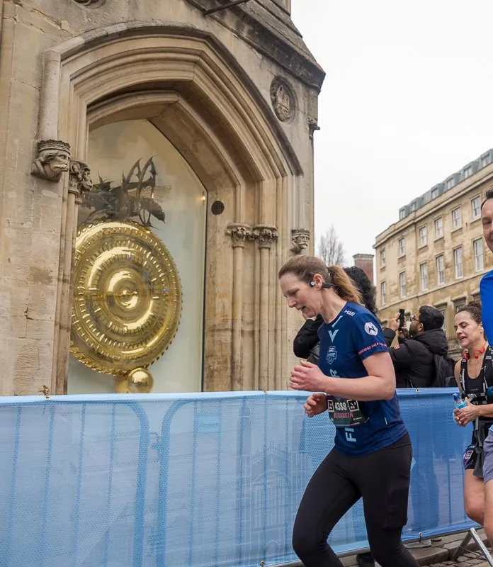 Runners passing the Corpus Clock at the Cambridge Half Marathon